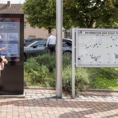 Digitales Gemeindeboard Ein Frau testet das digitale Gemeindeboard