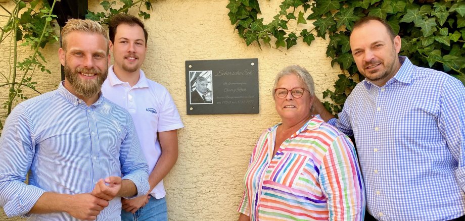 Gedenktafel zu Ehren von Georg Roth feierlich eingeweiht Vier Personen vor einer Gedenktafel