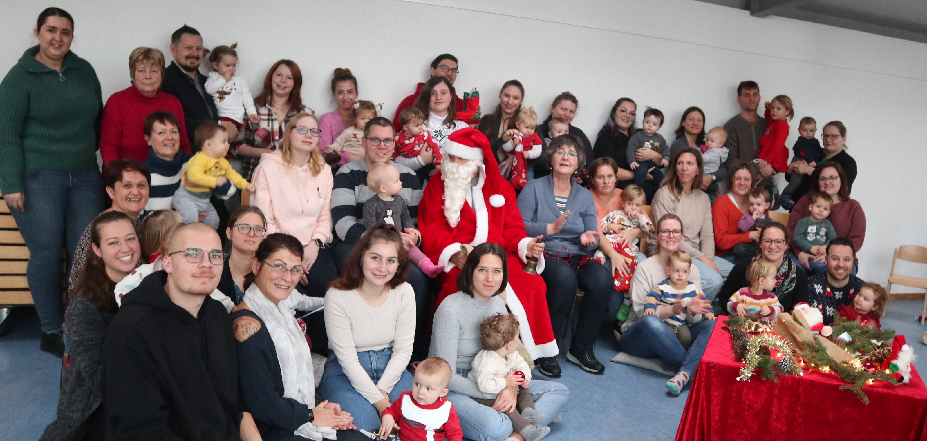 Gruppenbild mit Eltern und ihren Babys und dem Nikolaus in der Mitte 