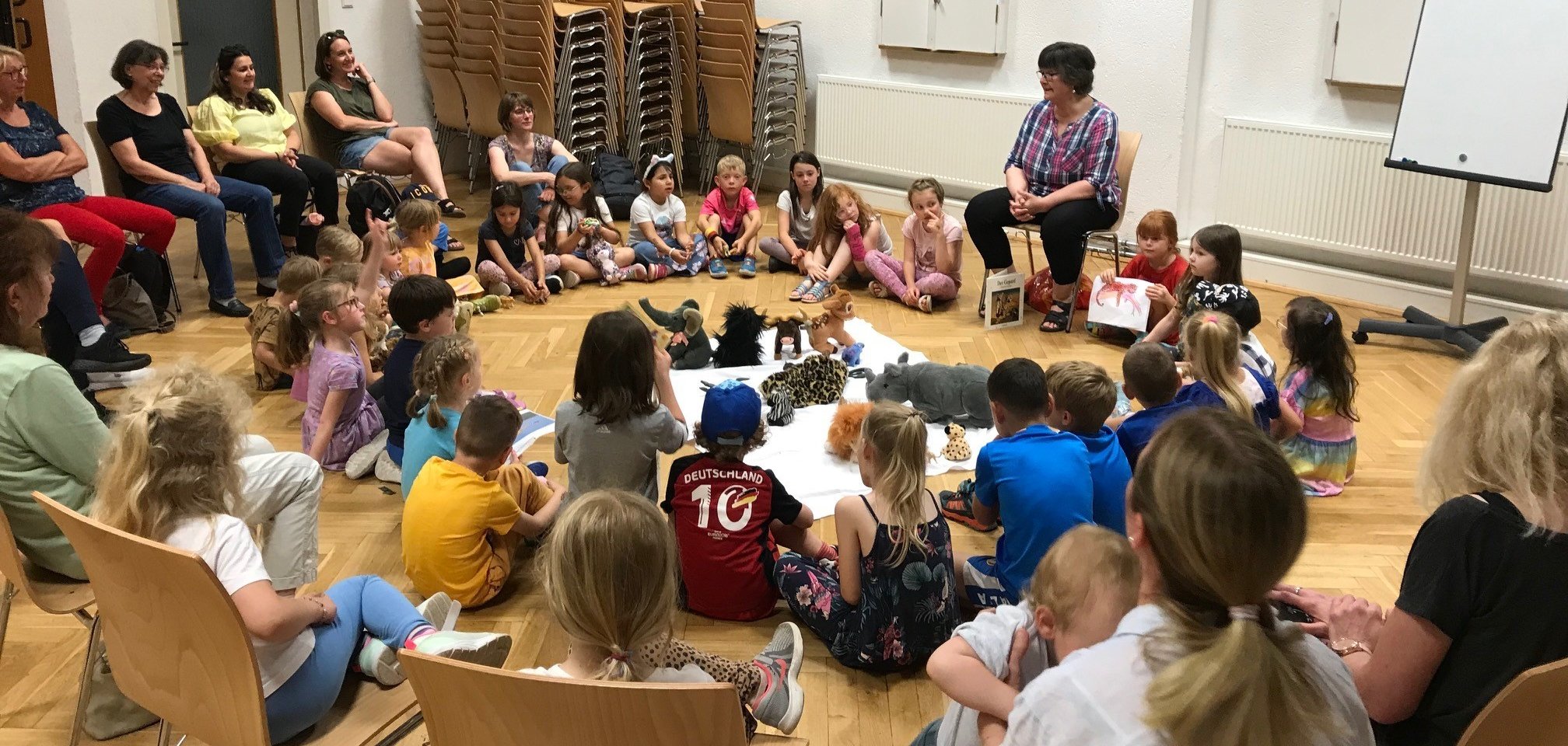 Eltern und Kinder sitzen im Kreis 