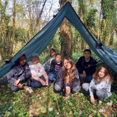 Kinder im Wald unter einem Zeltdach