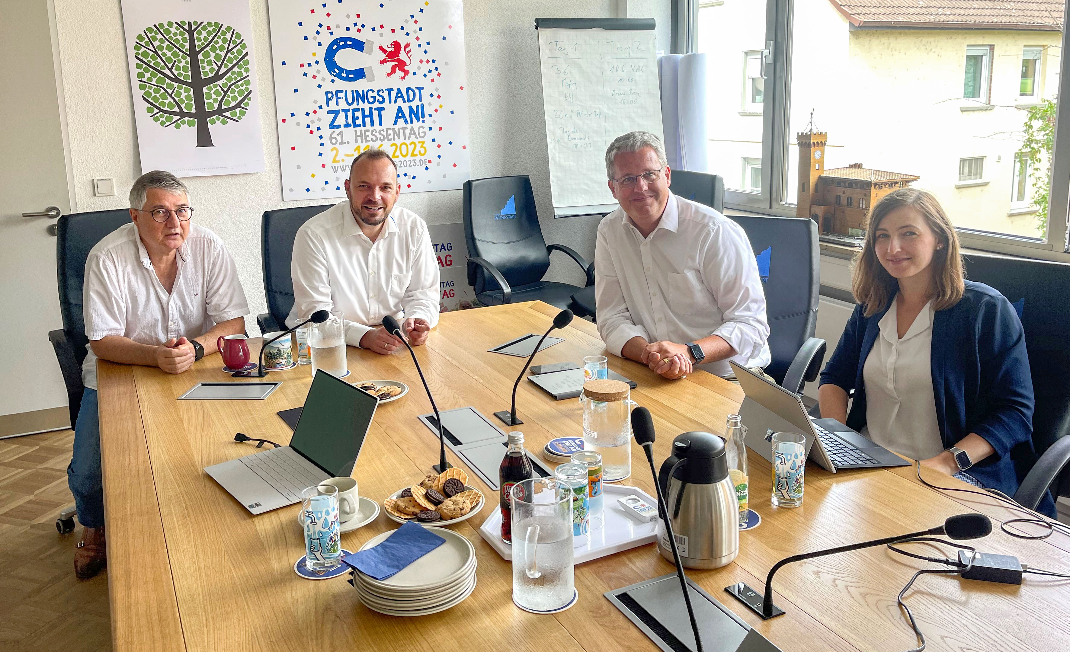 Drei Männer und eine Frau sitzen an einem Tisch