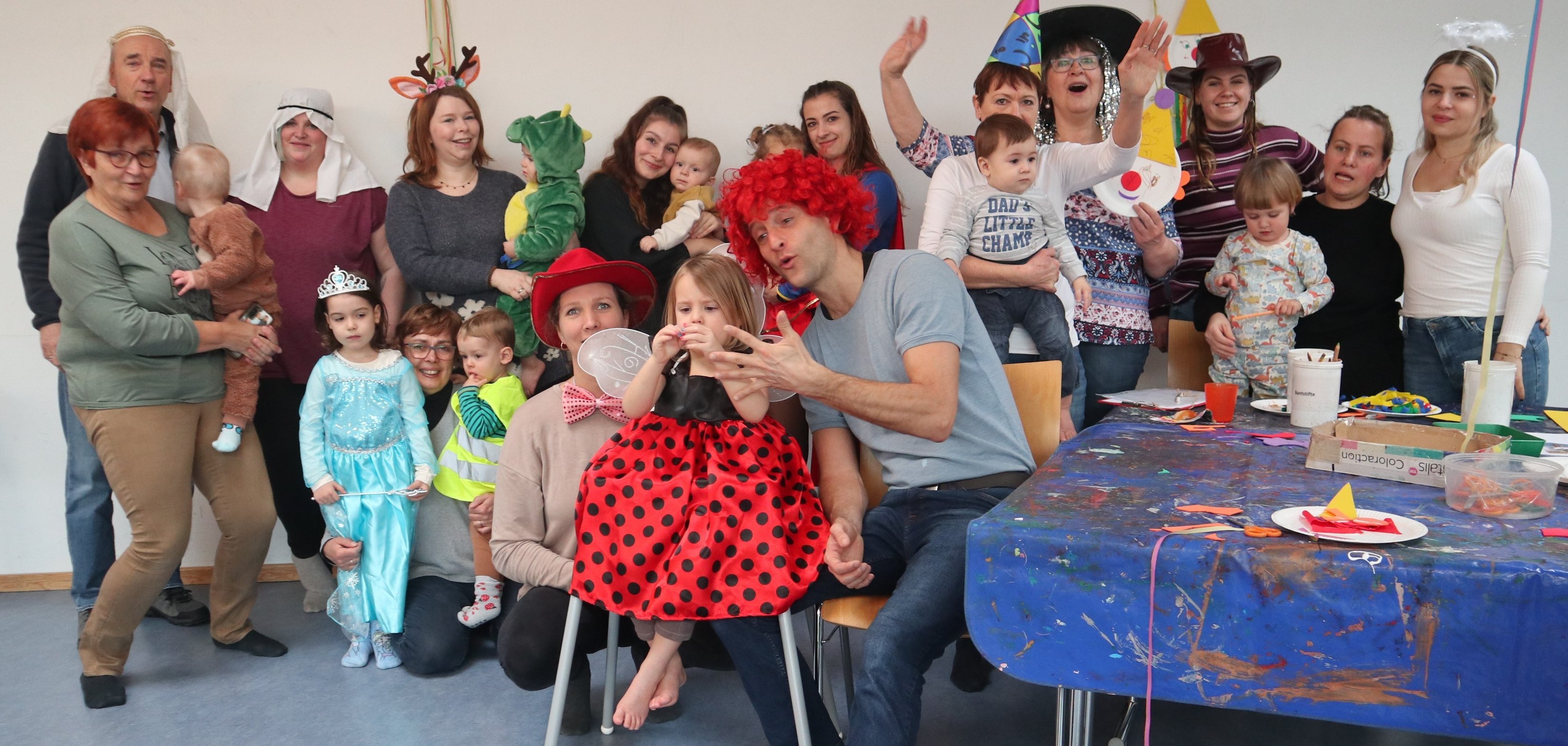 Gruppenbild mit verkleideten Kleinkindern und ihren Eltern