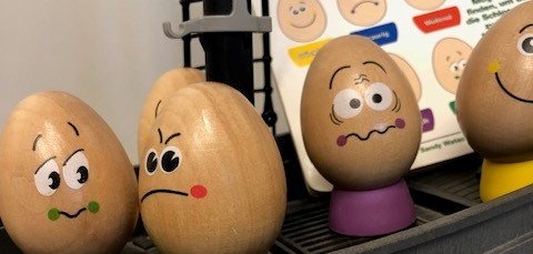 Bemalte Holzeier mit Gesichtsausdrücken