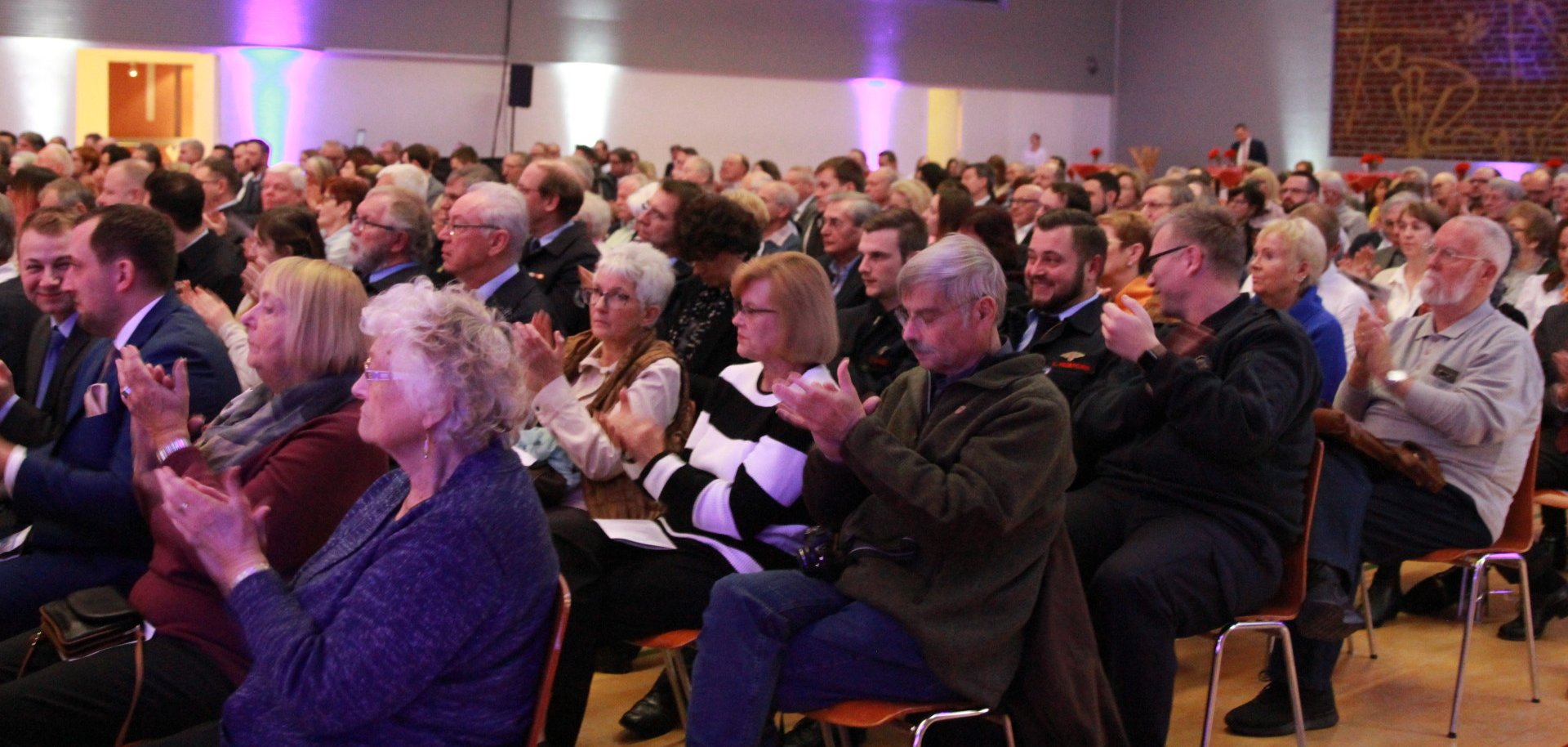 Publikum in einer großen Halle applaudiert 