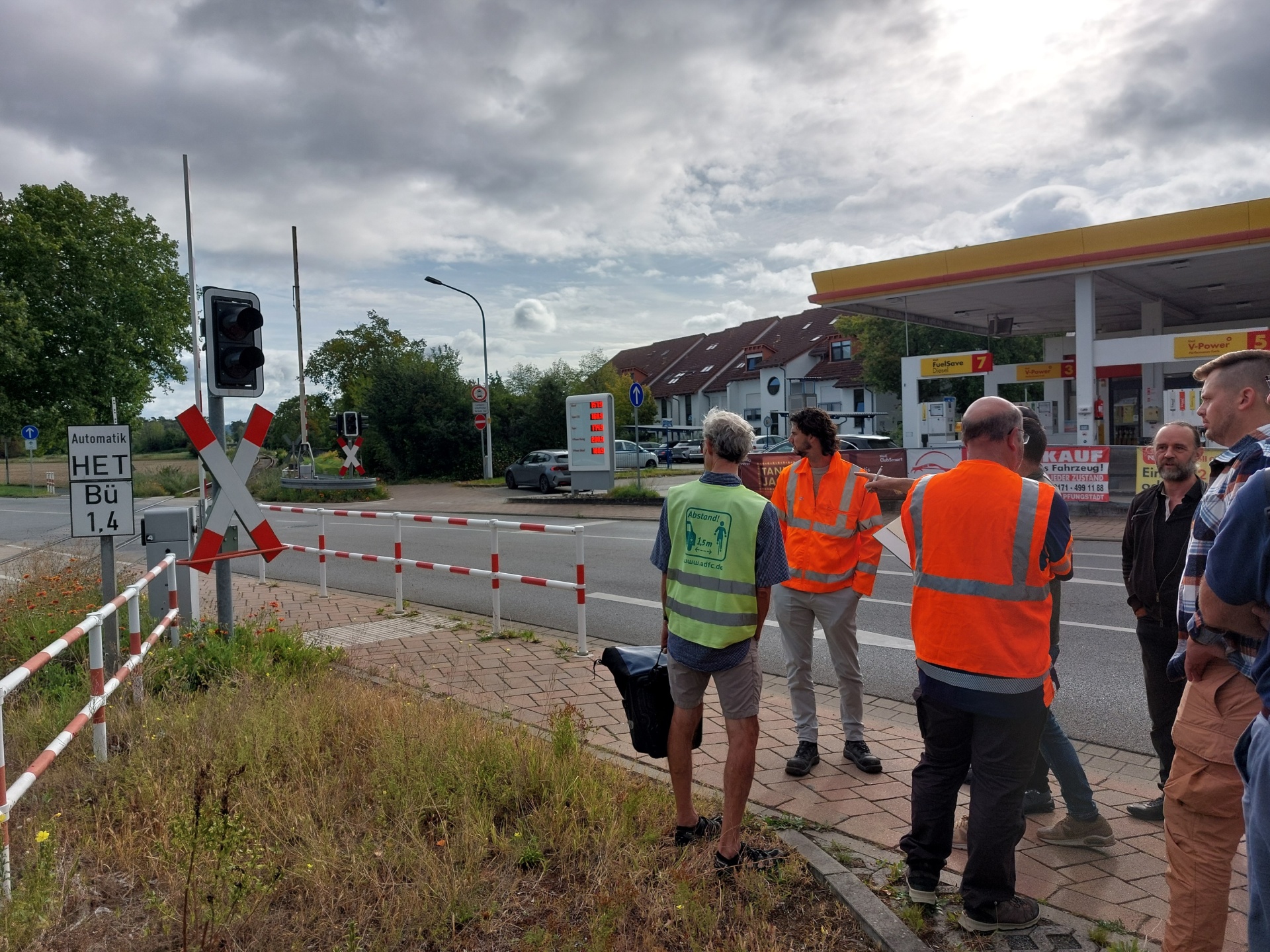 Menschen stehen an einem Bahnübergang