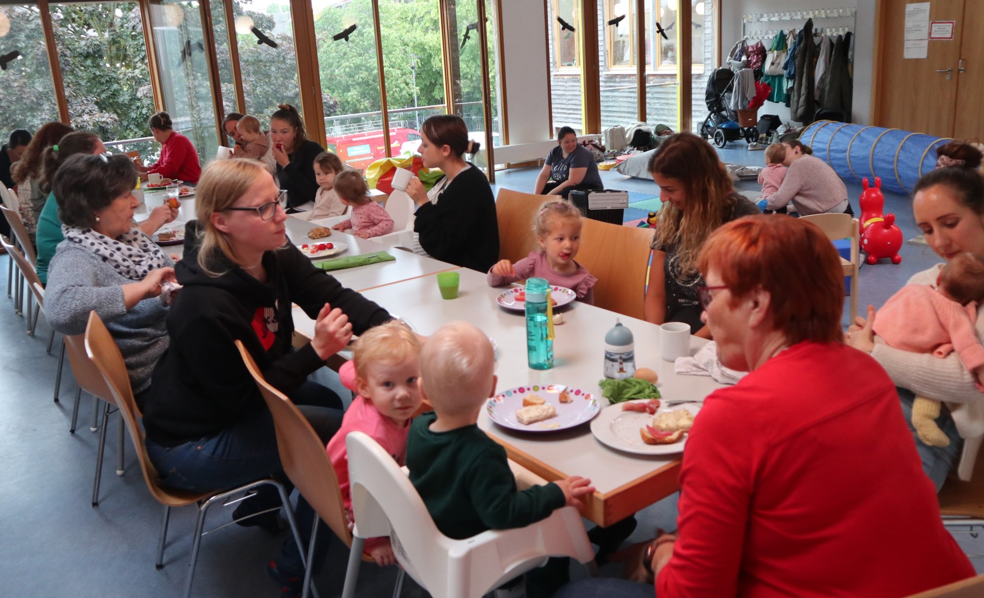 Eltern und Kinder sitzen an einem Tisch und essen Kuchen