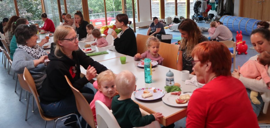 Eltern und Kinder sitzen an einem Tisch und essen Kuchen