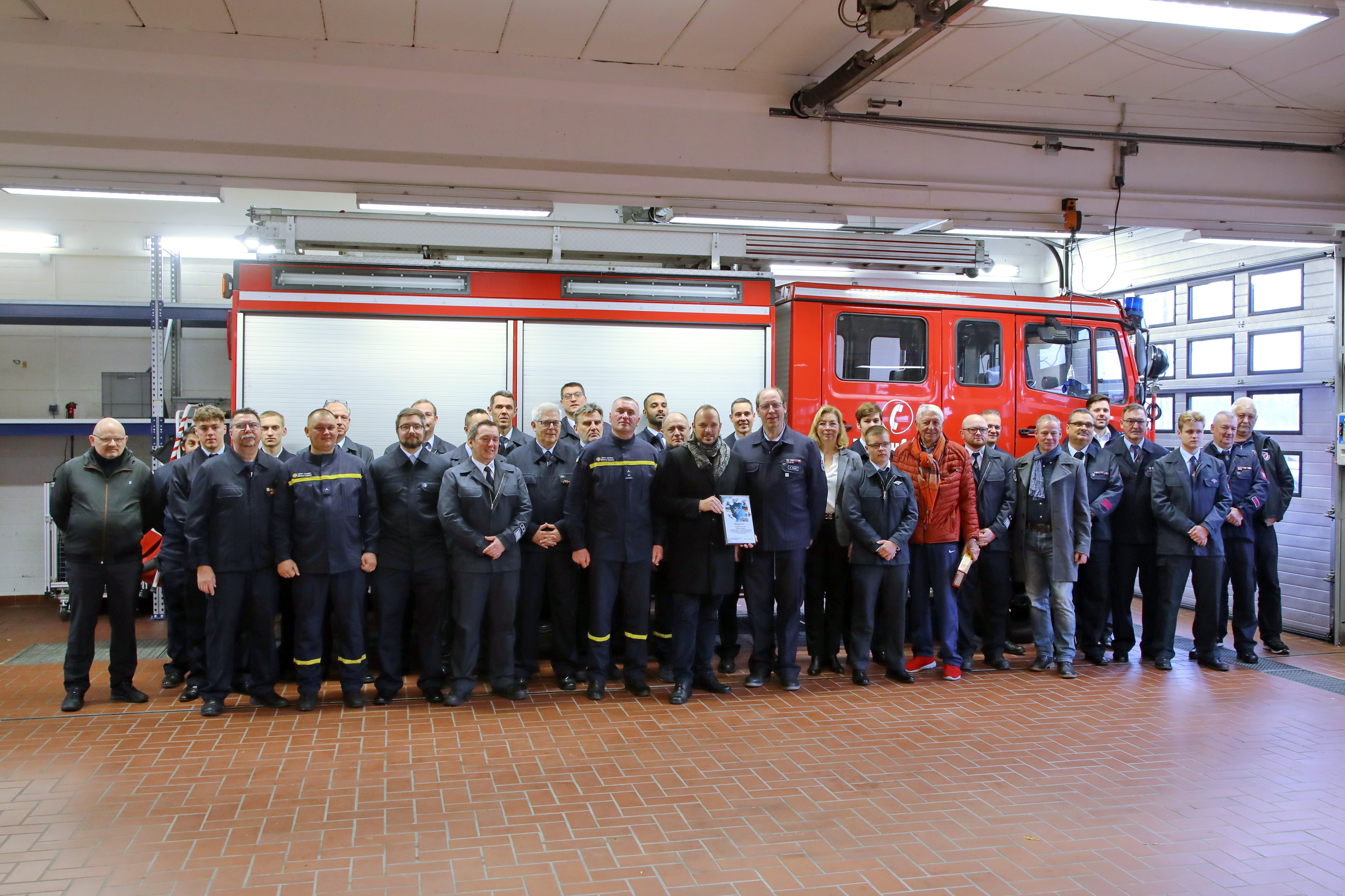 Feuerwehrleute vor Einsatzfahrzeug