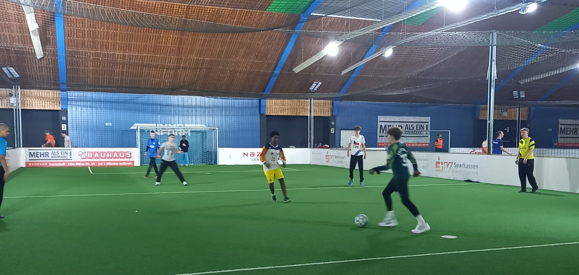 Kinder spielen Fußball in einer Soccerhalle