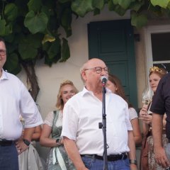 Drei Männer auf einer Bühne halten eine Rede