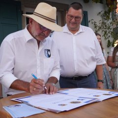 Ein Mann unterzeichnet eine Urkunde