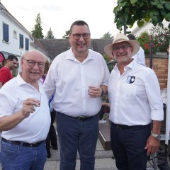Drei Herren mit Weinglas in der Hand