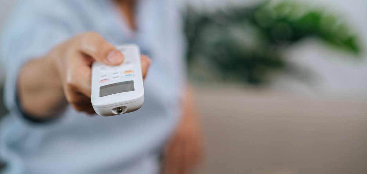 Frau, die eine Fernbedienung in der Hand hält