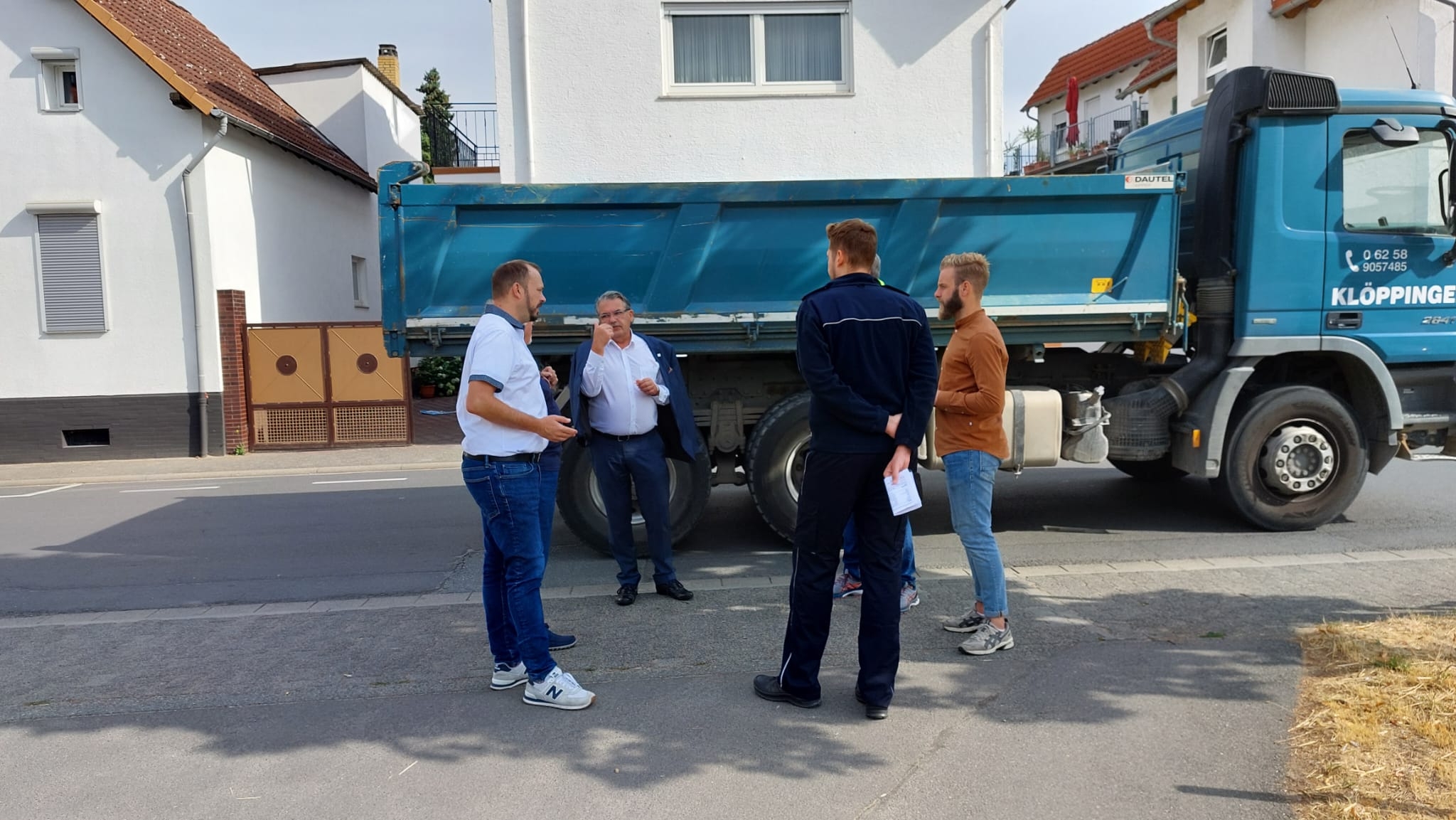 Personen stehen diskutierend vor einem Lkw