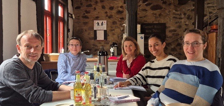 Männer und Frauen sitzen an einem Tisch 