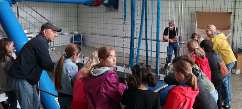 Mann mit Kindern im Gebäude eines Wasserwerks
