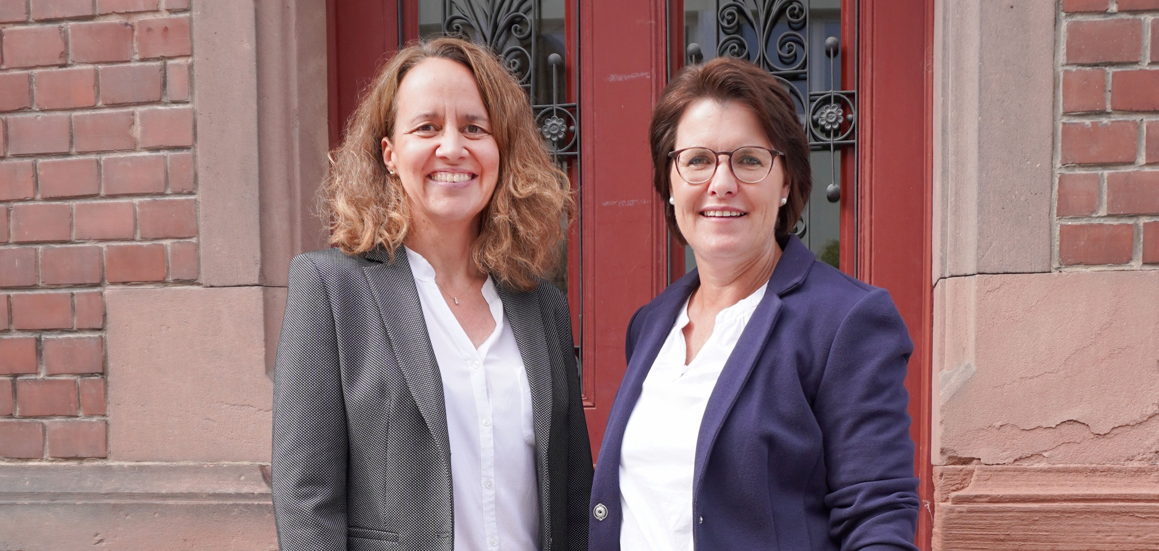 Zwei Frauen stehen auf einer Treppe vor einer Tür