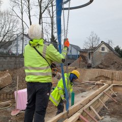 Bauarbeiter positioniert Trichter mit Beton