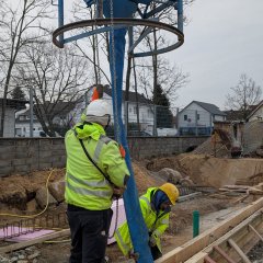 Bauarbeiter hält Trichter mit Beton über Einfüllstelle