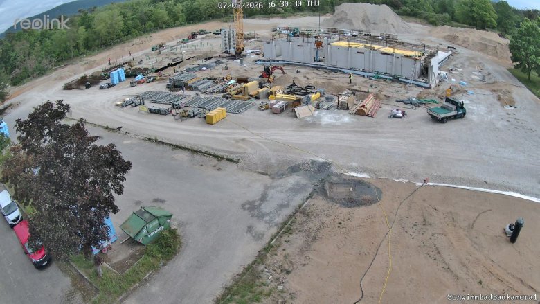 Großbaustelle mit vielen Gerätschaften im Vordergrund und diversen Rohren