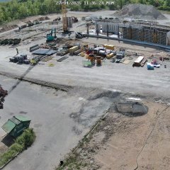 Großbaustelle mit Betonplatte und Wänden sowie Sandhügel im Hintergrund