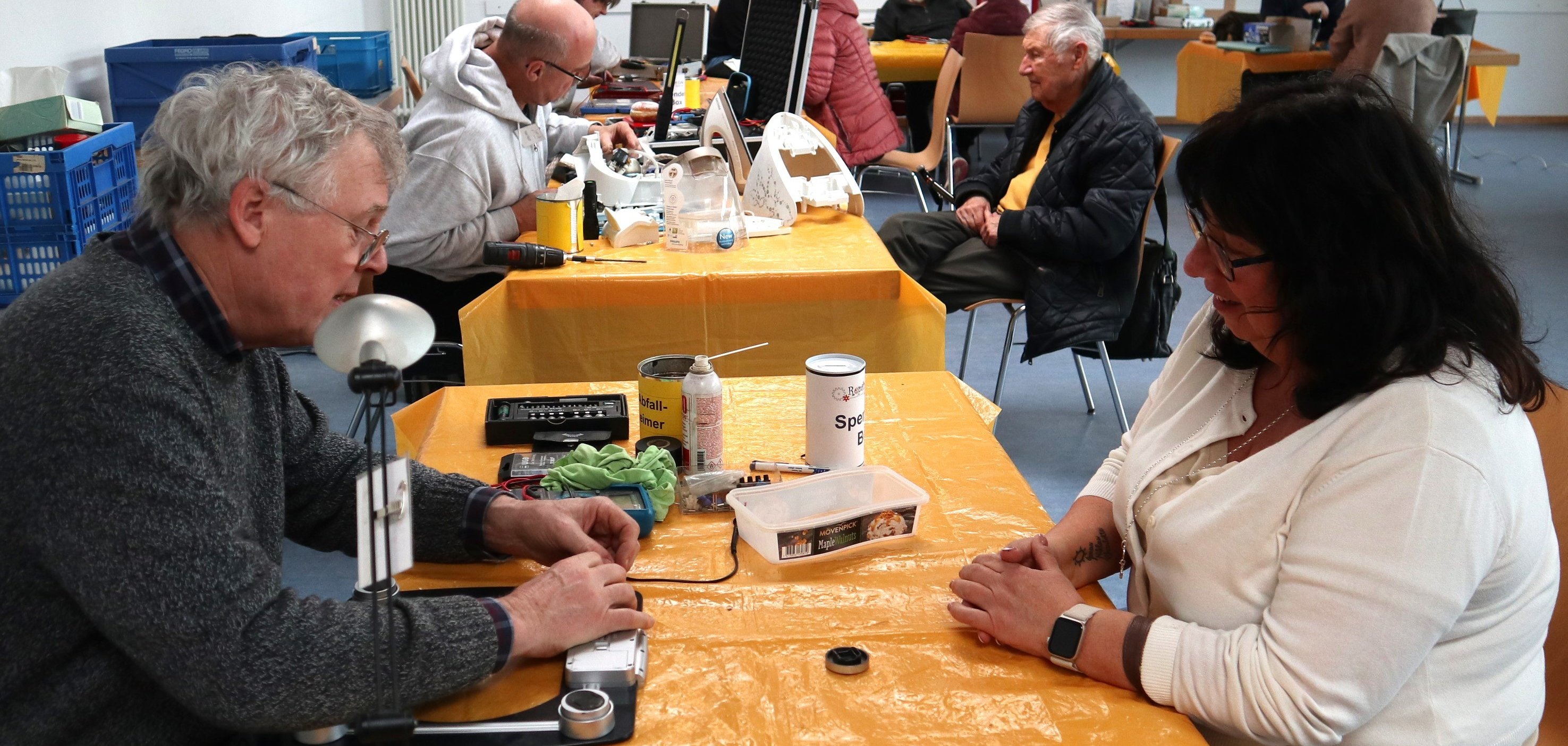 Menschen am Tisch reparieren Gegenstände