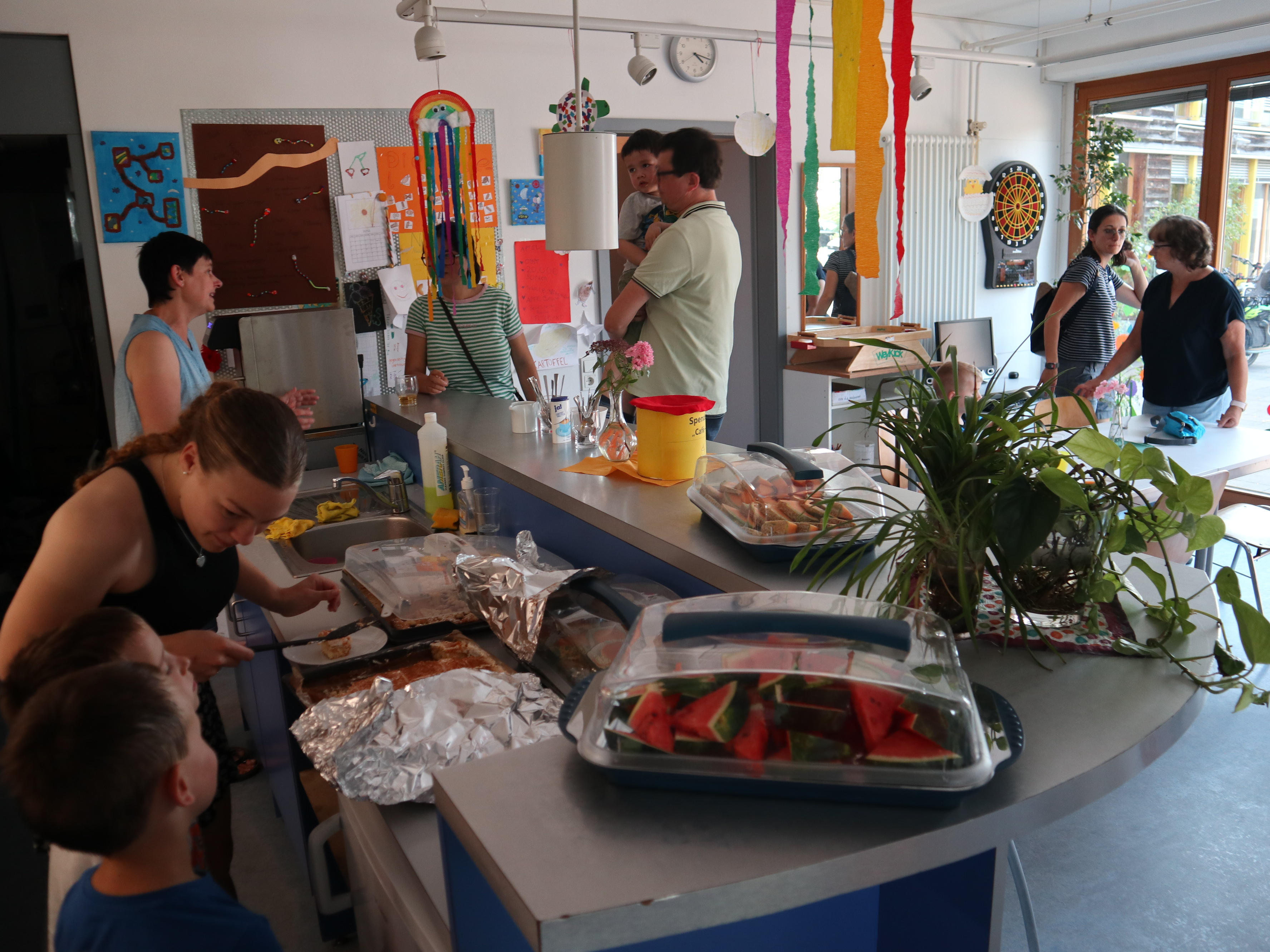 Junge Frau verteilt Kuchen an Kinder und Erwachsene