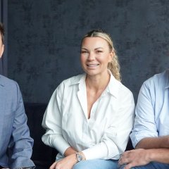 Frau und zwei Männer sitzen auf einem Sofa 