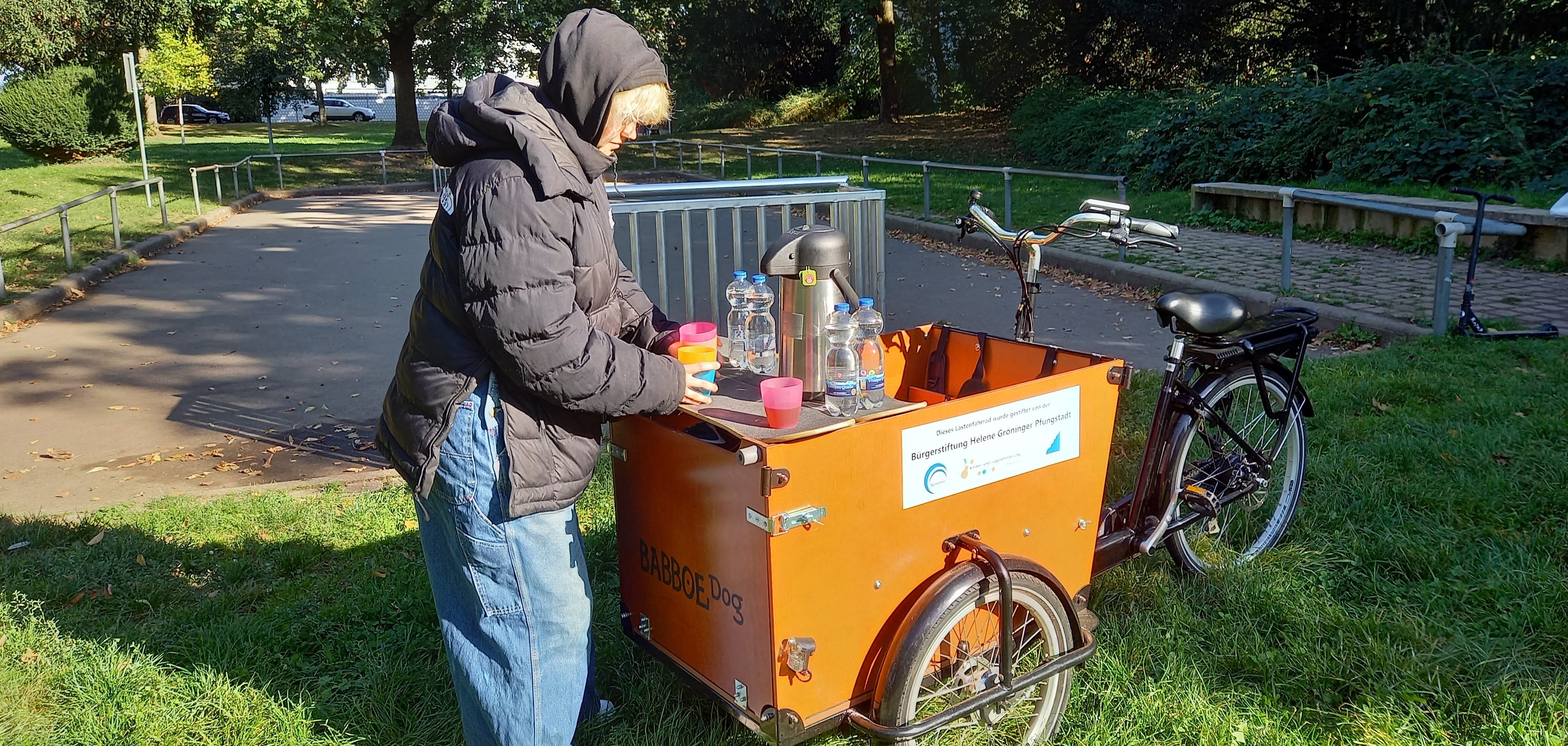 Frau steht an einem Lastenfahrrad
