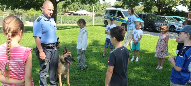 Polizist stellt Kindern einen Polizeihund vor