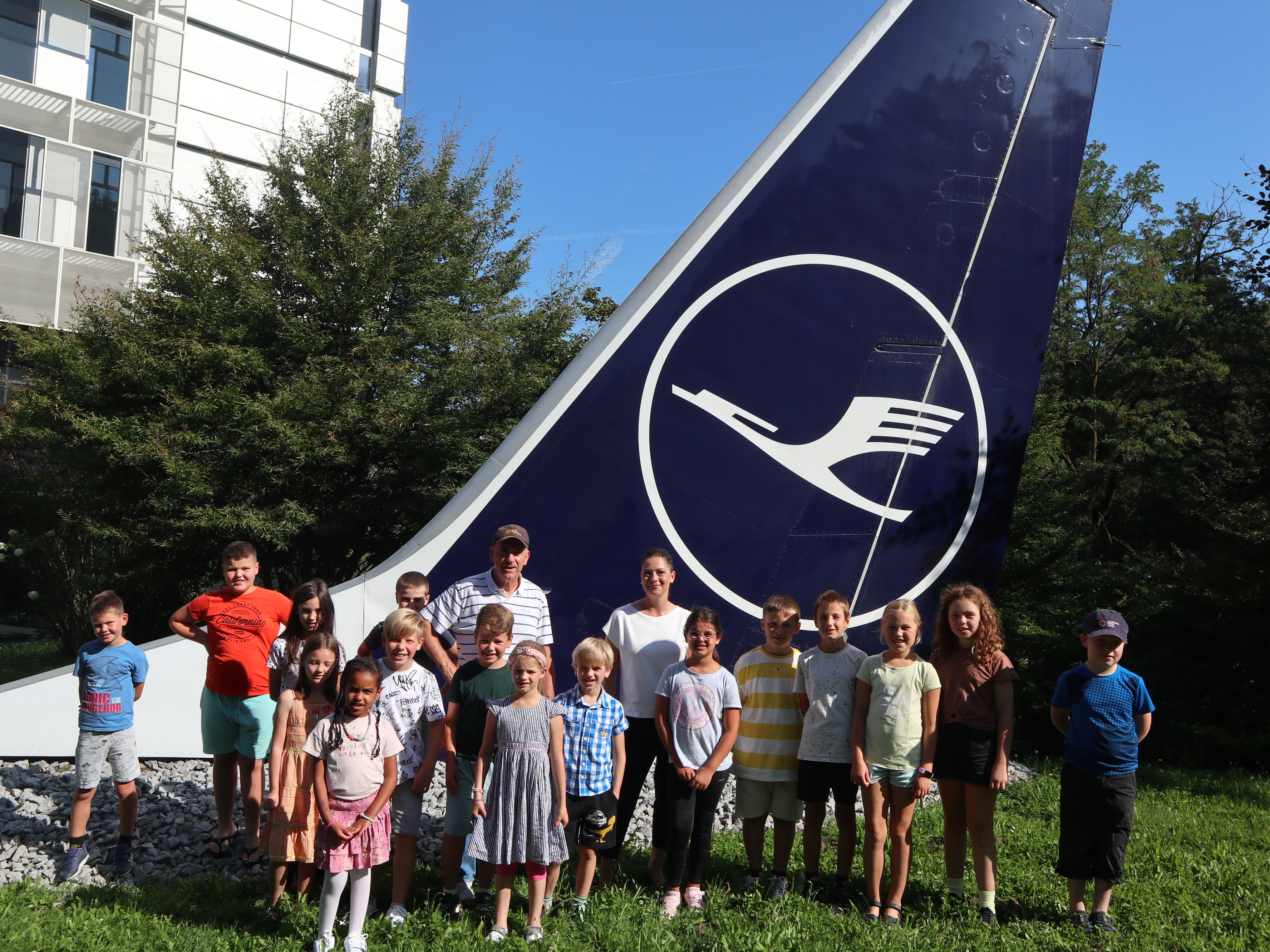 Kinder-Gruppenfoto vor dem Seitenruder eines Lufthansa-Flugzeuges