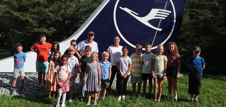 Kinder-Gruppenfoto vor dem Seitenruder eines Lufthansa-Flugzeuges