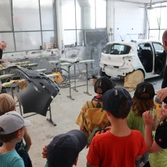Kinder beobachten Mechaniker bei der Arbeit in der Werkstatt