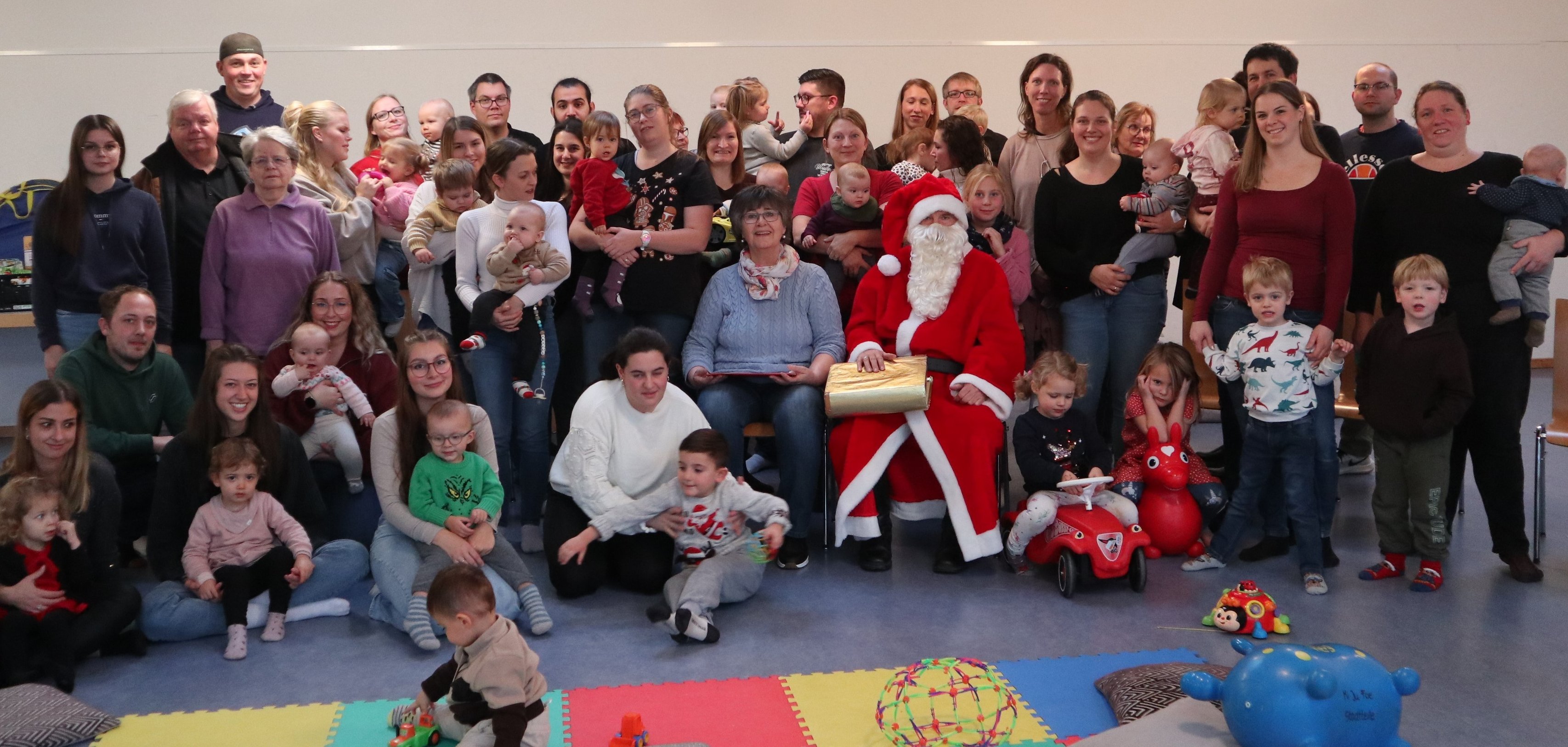 Gruppenbild mit vielen Menschen und dem Nikolaus in der Mitte