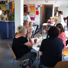 Erwachsene spielen mit ihren Kindern gemeinsam an einem Tisch