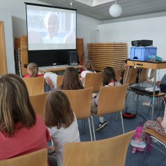 Kinder schauen einen Film auf einer Leidwand