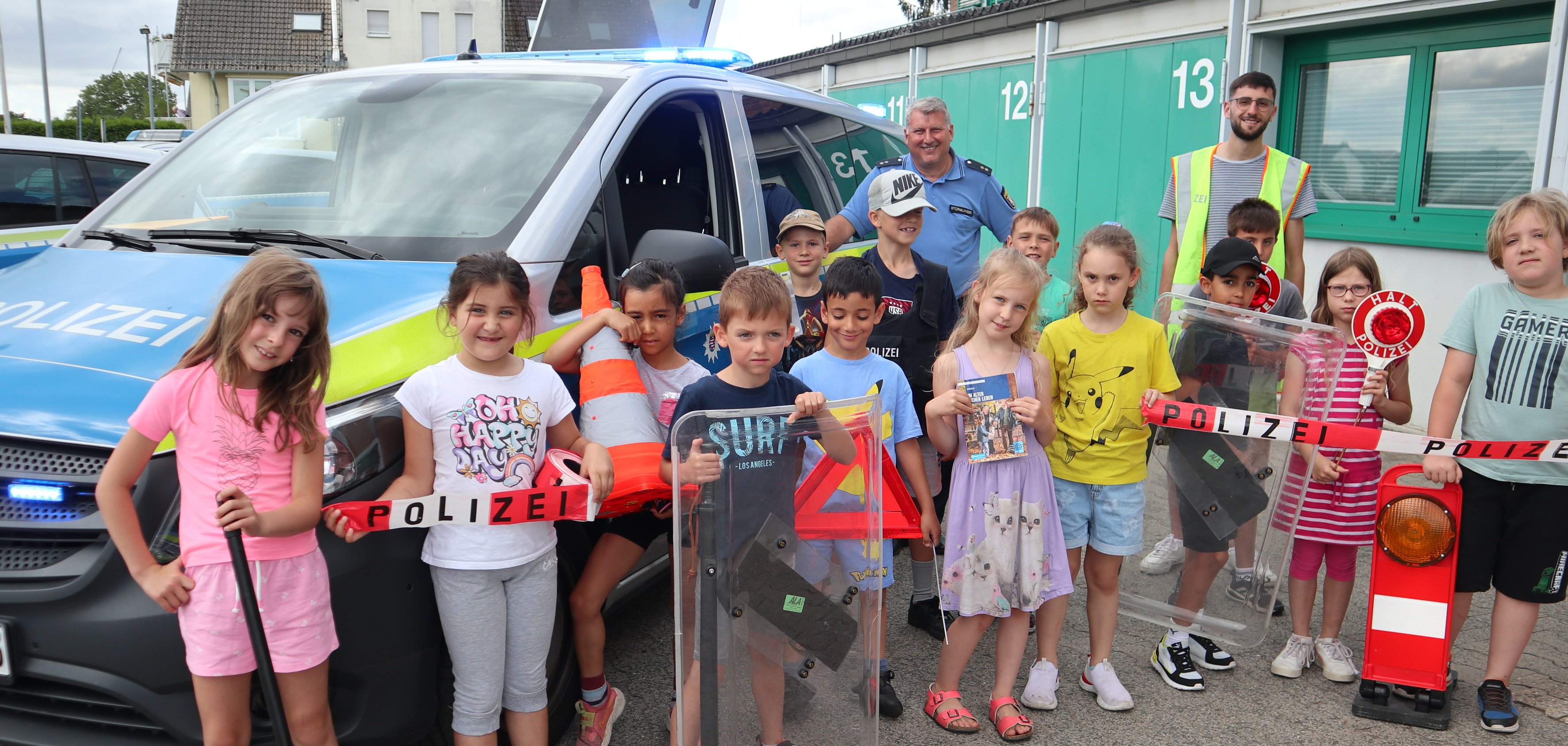 Kinder-Gruppenbild vor einem Polizeiauto