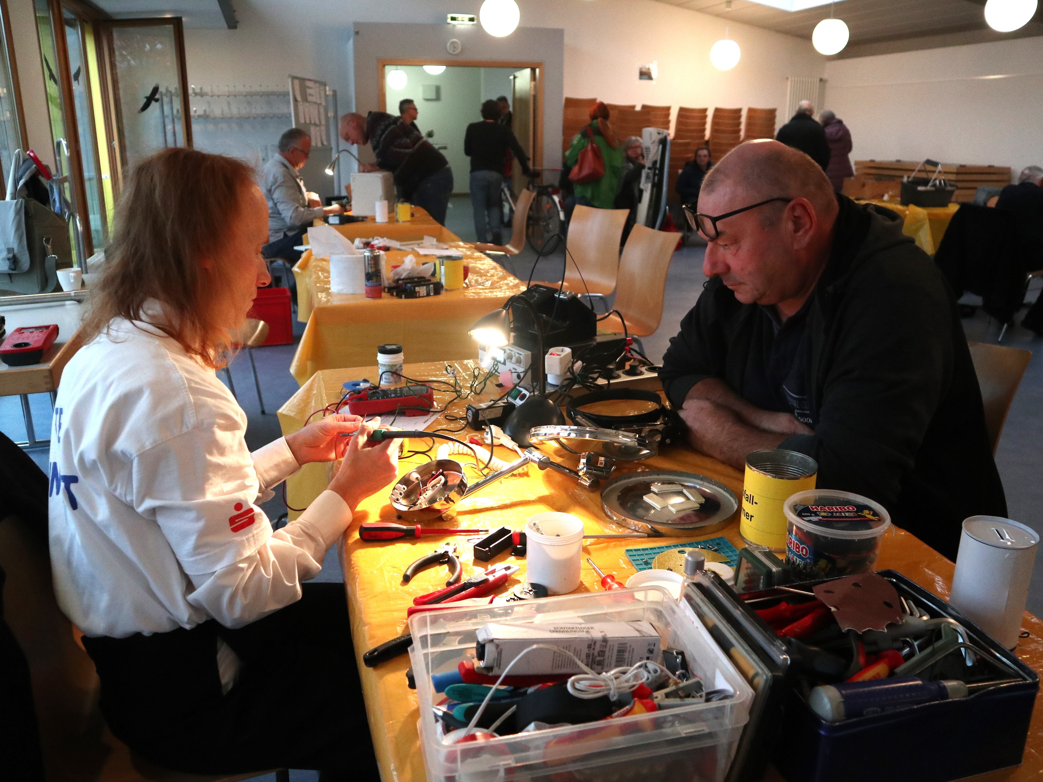 Eine Frau repariert das Gerät eines Mannes