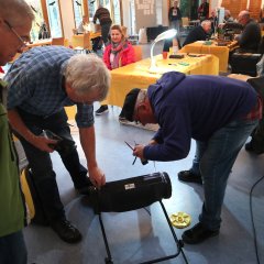 Drei Männer reparieren ein Gerät