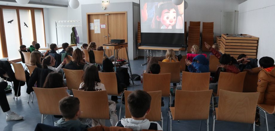 Kinder schauen sich einen Film auf einer Leinwand an