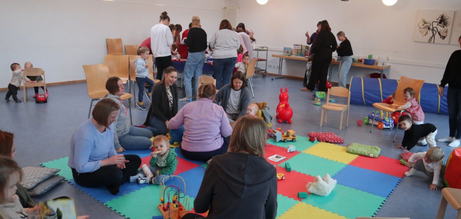 Eltern mit Kindern sitzen auf dem Boden