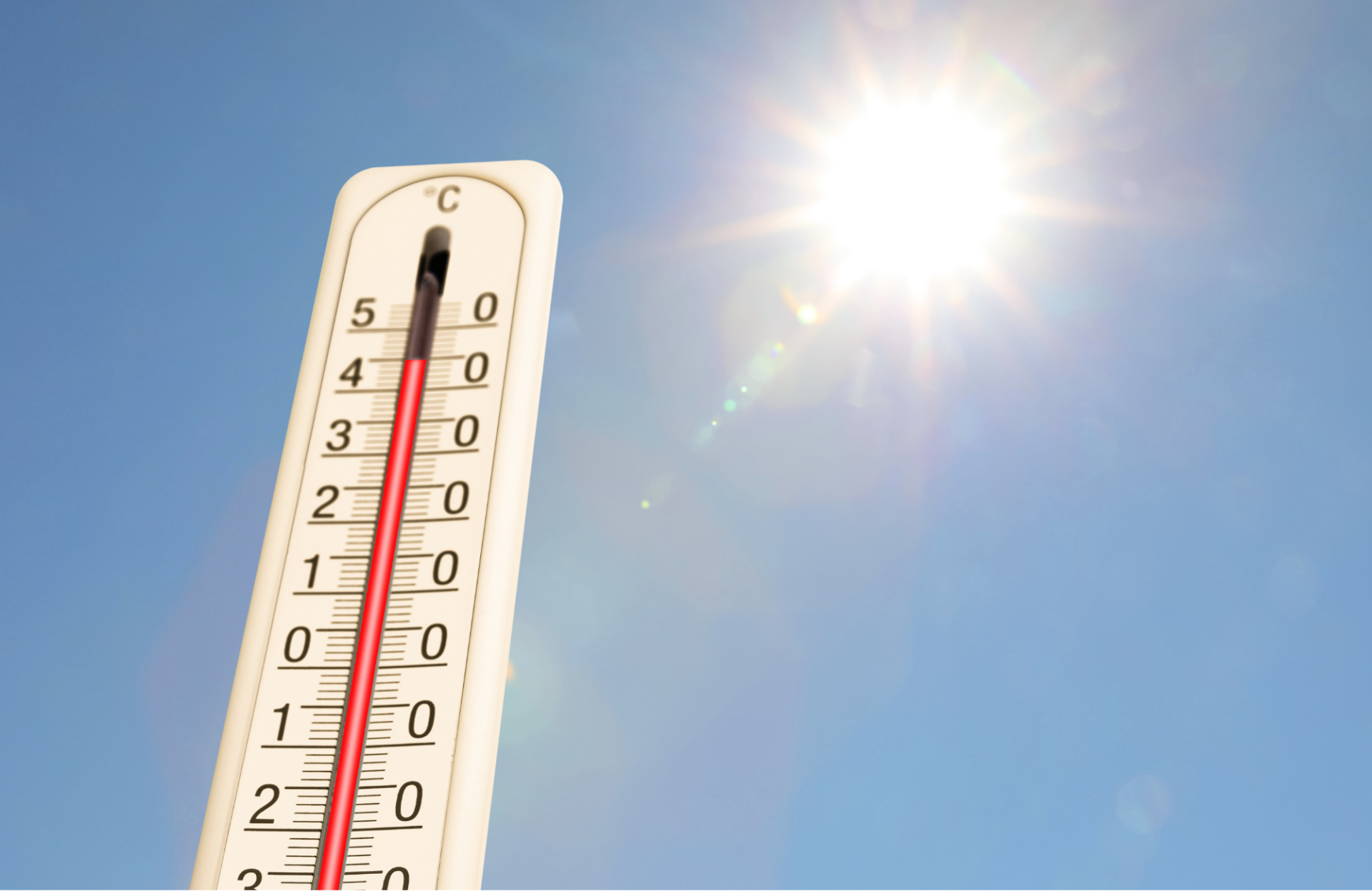 Angepasste Schließzeiten des Wertstoffhofs bei hohen Temperaturen Blauer Himmel und Sonne. Im Vordergrund ein Termometer