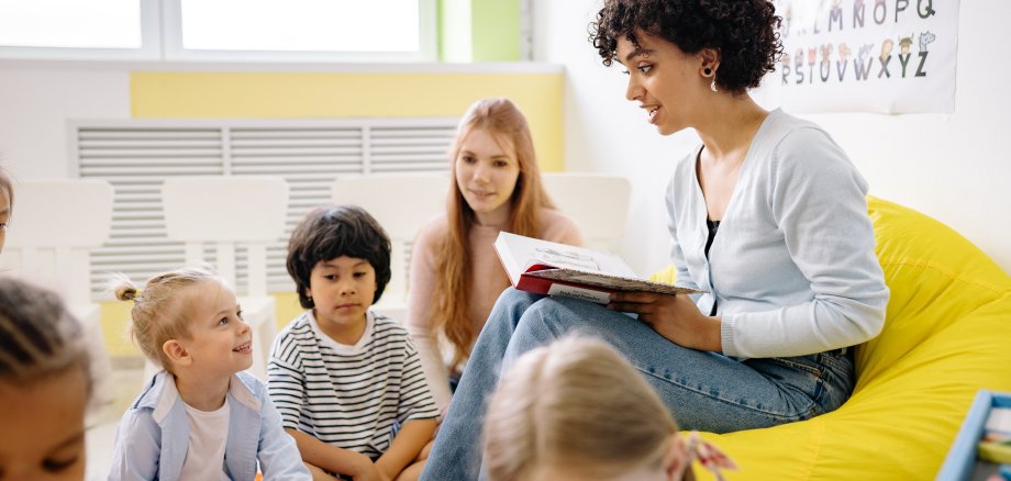 Frau liest Kindern aus einem Buch vor