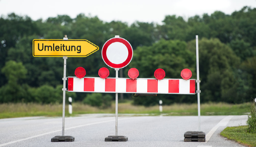 Abgesperrte Straße mit Bake und Umleitungsschild