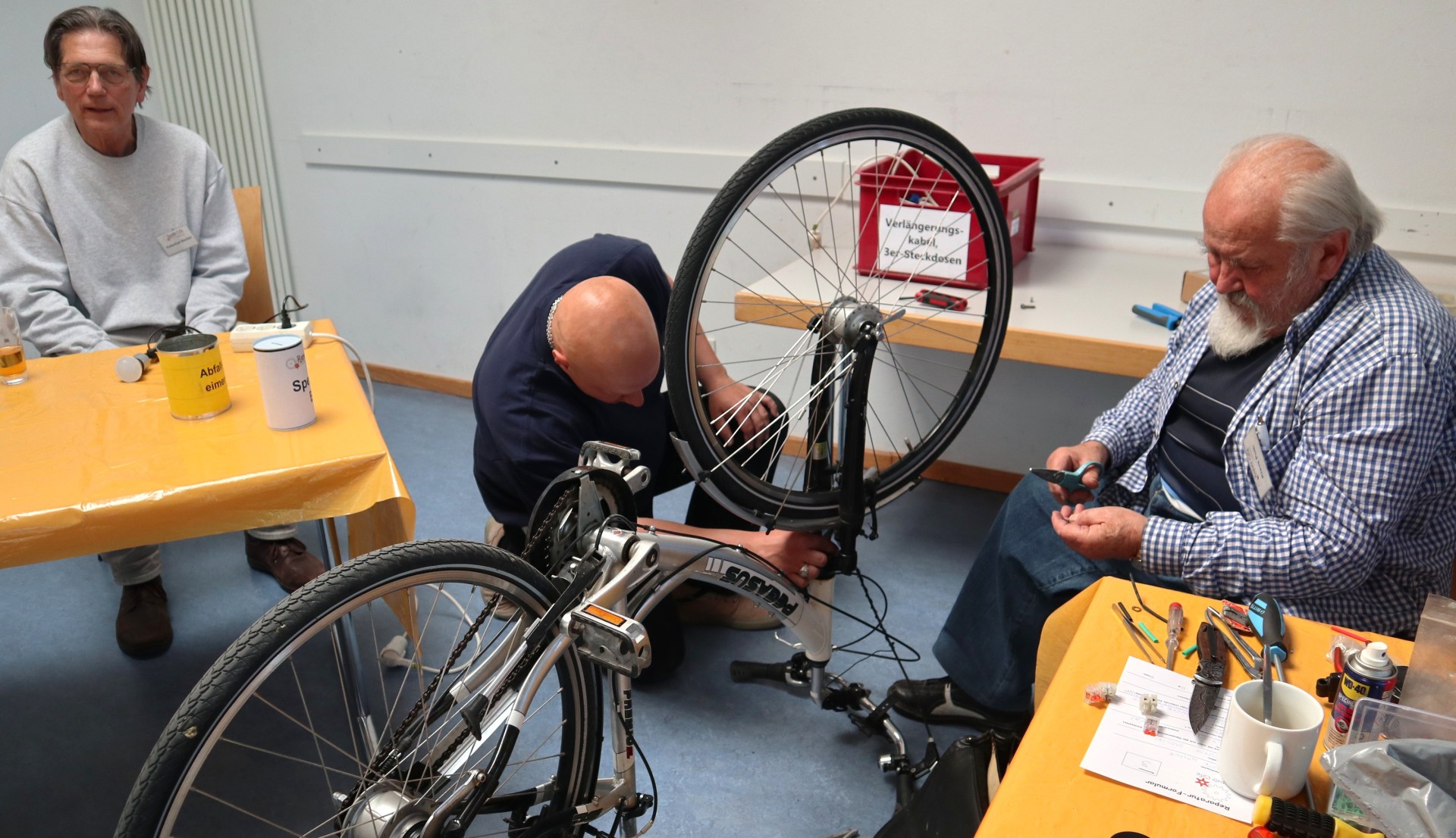 Mehr als die Hälfte der Geräte erfolgreich repariert im Repair-Café Pfungstadt-Eschollbrücken Männer reparieren ein Fahrrad