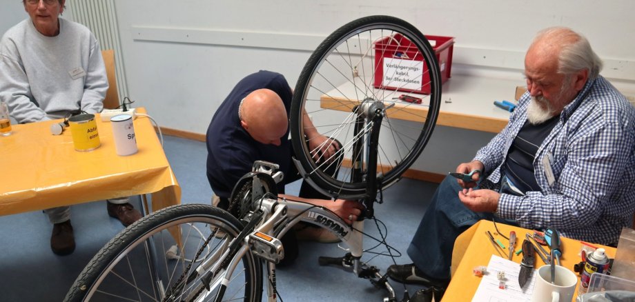 Mehr als die Hälfte der Geräte erfolgreich repariert im Repair-Café Pfungstadt-Eschollbrücken Männer reparieren ein Fahrrad