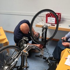 Mehr als die Hälfte der Geräte erfolgreich repariert im Repair-Café Pfungstadt-Eschollbrücken Männer reparieren ein Fahrrad